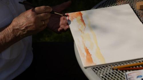 De maker van kunst aan het werk in de tuin
