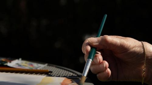 De maker van kunst aan het werk in de tuin