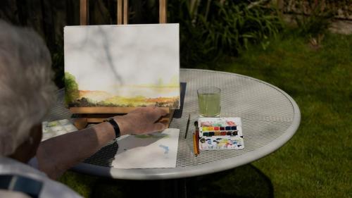 De maker van kunst aan het werk in de tuin