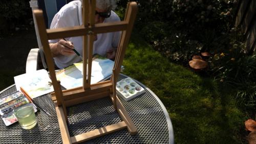 De maker van kunst aan het werk in de tuin